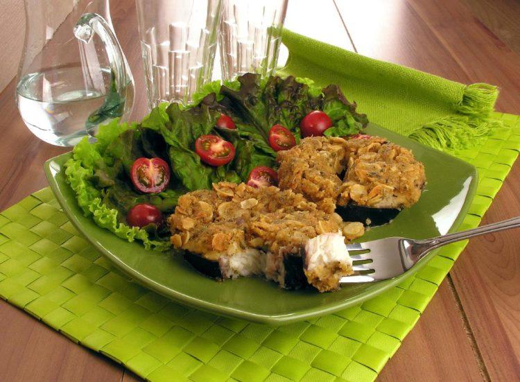 receita de peixe com crosta de amêndoas, acompanhado de salada verde com tomates