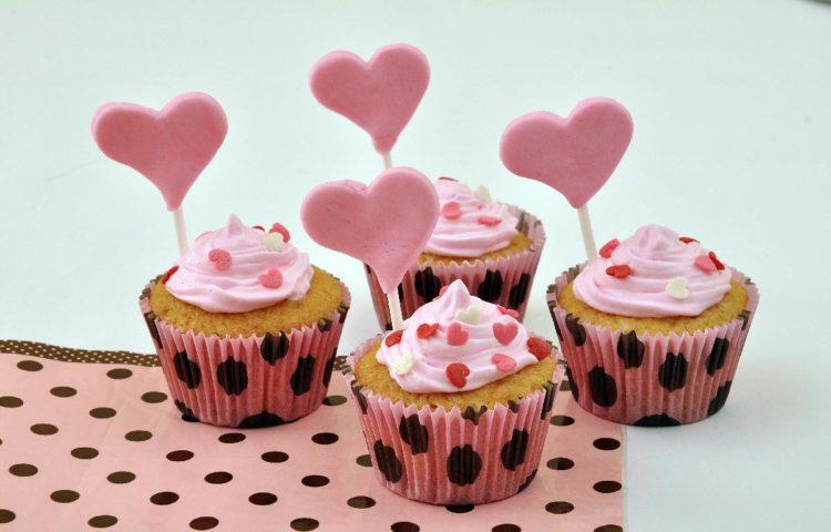 cupcake bicho de pé, forminha rosa com poás pretos, cobertura rosa e confeitos de coração, pirulito de coração rosa