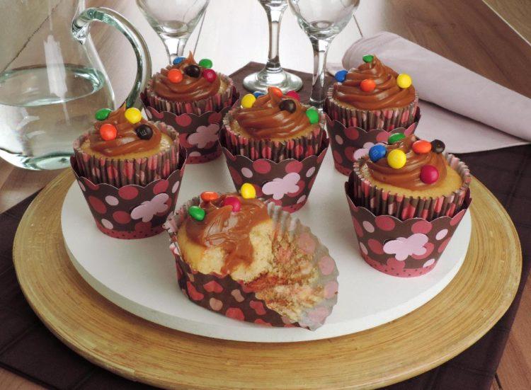 receita de cupcake de doce de leite, com recheio aparente e decorado com M&M's