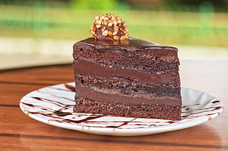 Bolo de chocolate no prato em camadas com recheio de chocolate.