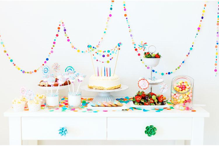 Mesa de festa de aniversário com bolo e docinhos decorados.