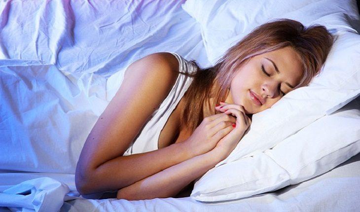 A foto mostra uma mulher deitada dormindo tranquila