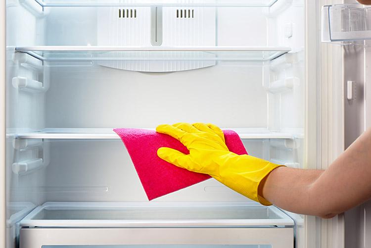 mulher limpando a geladeira