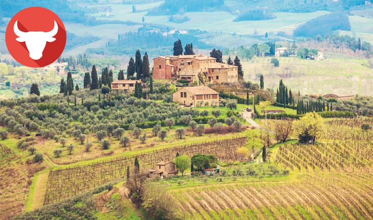 Imagem da Toscana, com fazenda e ambiente bem verde com simbolo de Touro ao lado