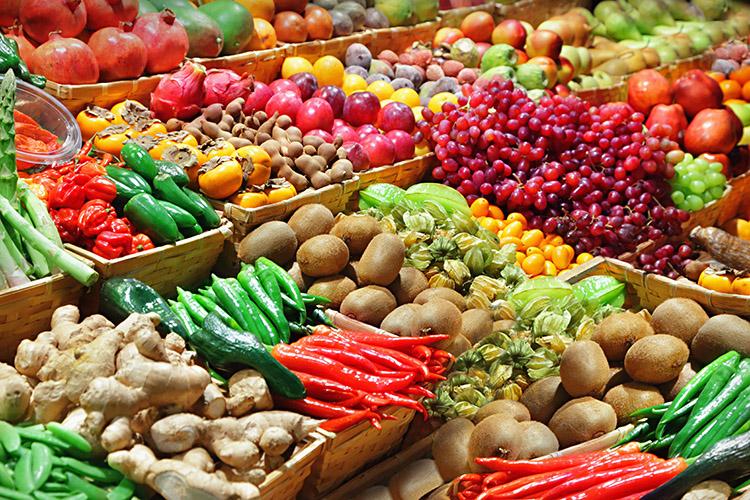 Alimentos, frutas, e legumes em uma banca de feira.