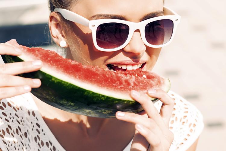 mulher comendo melancia, alimento com calorias negativas