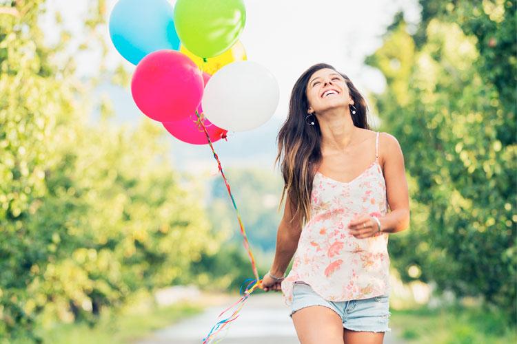 Mulher feliz segurando balões
