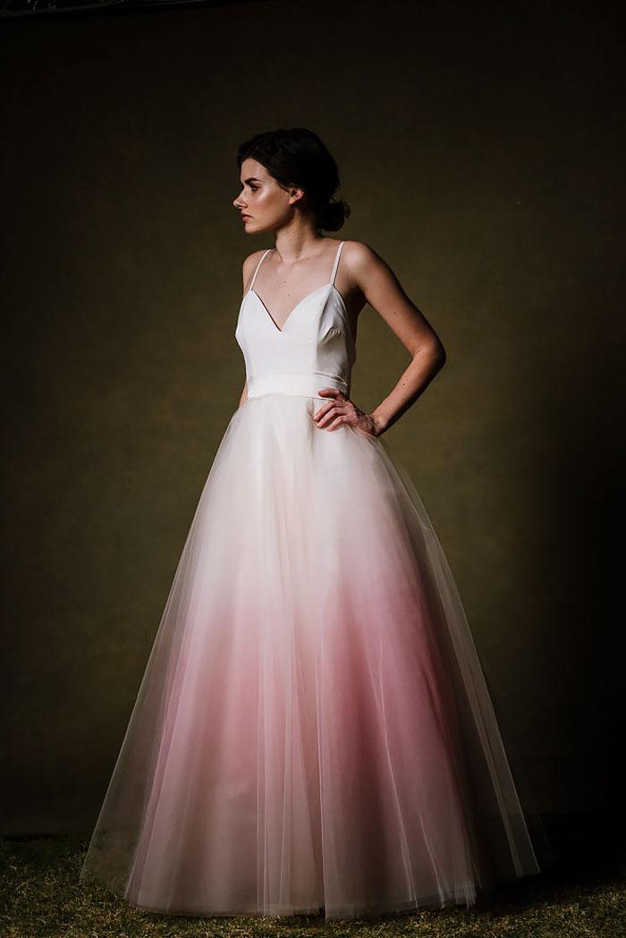 Noiva posa para foto com vestido branco e rosa