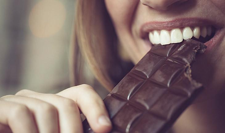 mulher mordendo barra de chocolate