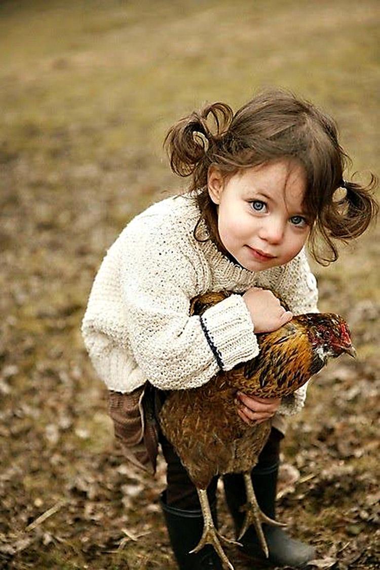 Menina abraçando galinha