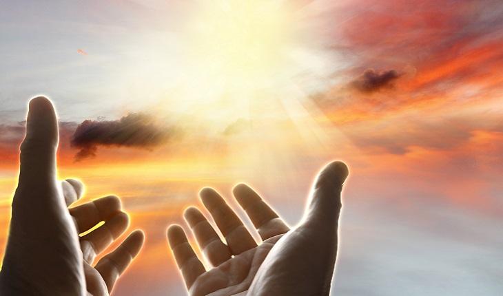 A foto mostra uma pessoa erguendo as mãos em direção a uma luz forte no céu. A foto ilustra a existência de um dos 7 céus