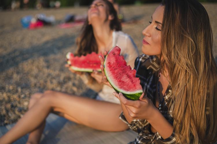 meninas comendo melancia na praia