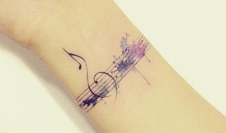 tatuagem aquarela de notas musicais