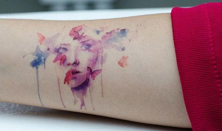 tatuagem aquarela de rosto feminino com borboletas