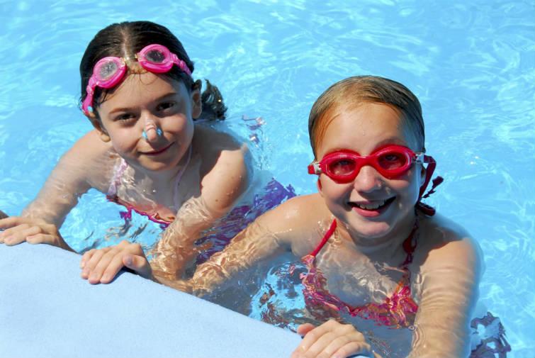 Duas meninas na piscina com equipamentos