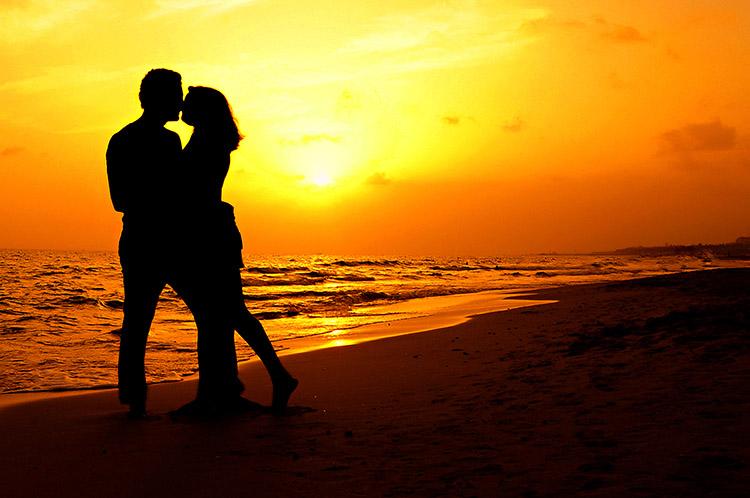 casal na praia e pôr do sol