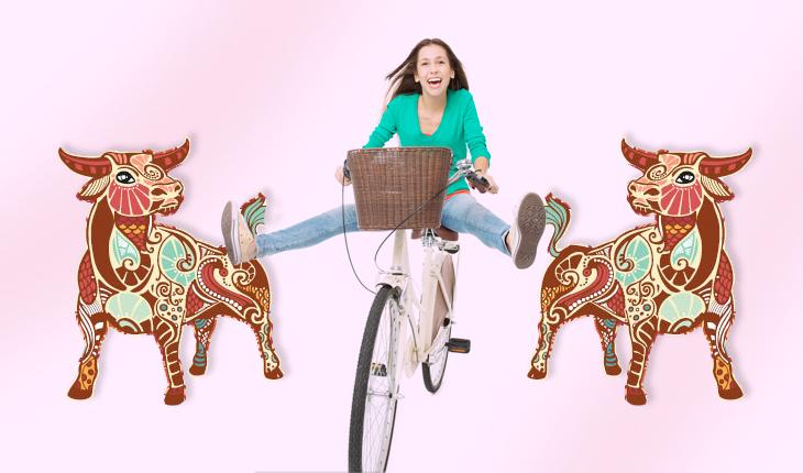 mulher andando de bicicleta e simbolo touro