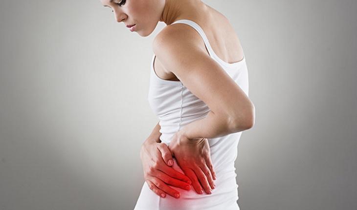 A foto mostra uma mulher com a mão em um ponto em vermelho nas suas costas, como se estivesse recebendo radiação infravermelha , uma das terapias eficientes contra artrite e artrose