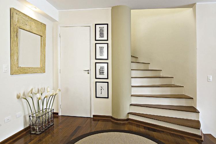 Escada branca, com parede ao lado e quadros