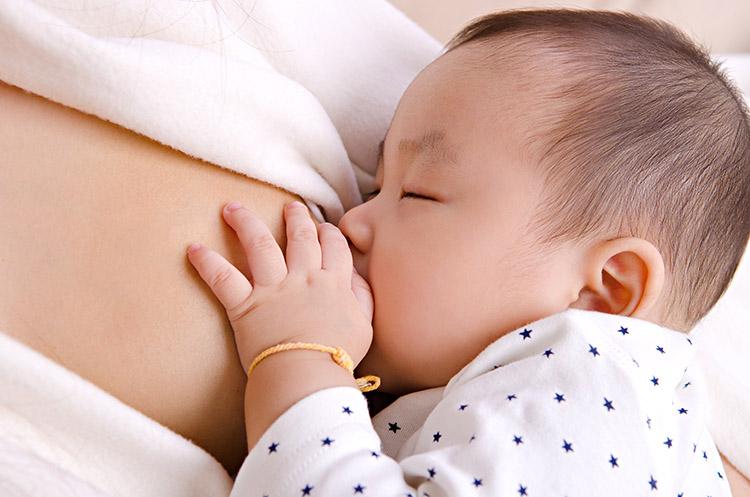 bebê mamando no seio feminino