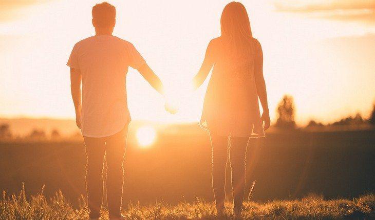 Benzeduras para ter uma vida amorosa feliz. Na foto, um homem e uma mulher de mão dadas olhando o por do sol
