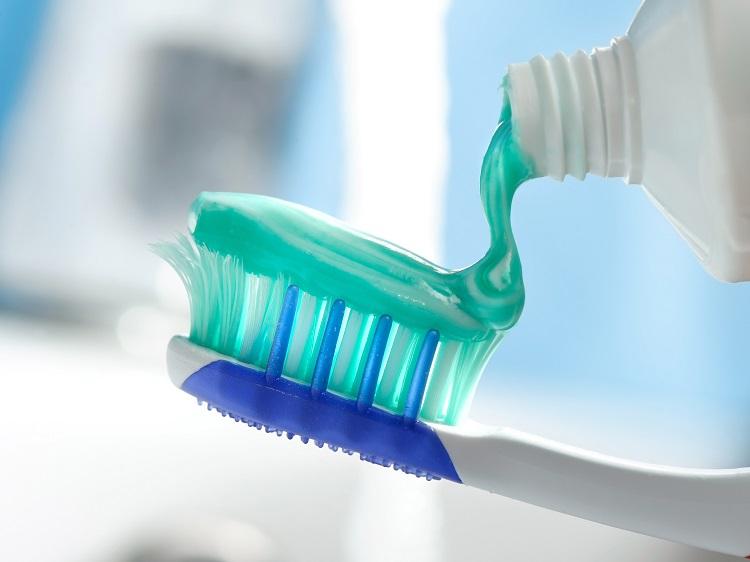 escova de dentes ideal, branca com azul com pasta verde.