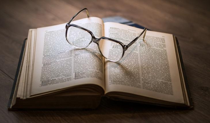 óculos sobre livro mostrando sabedoria