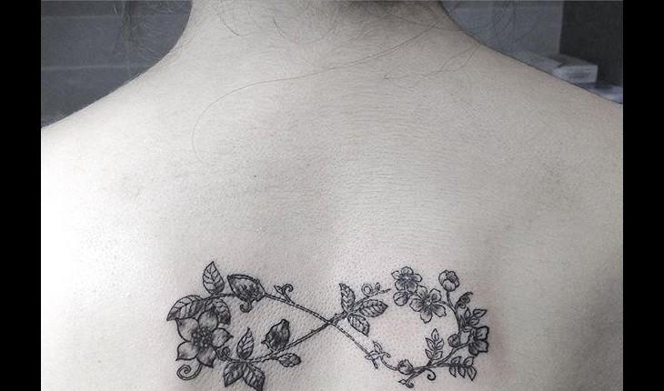 Tatuagem em preto com flores e infinito
