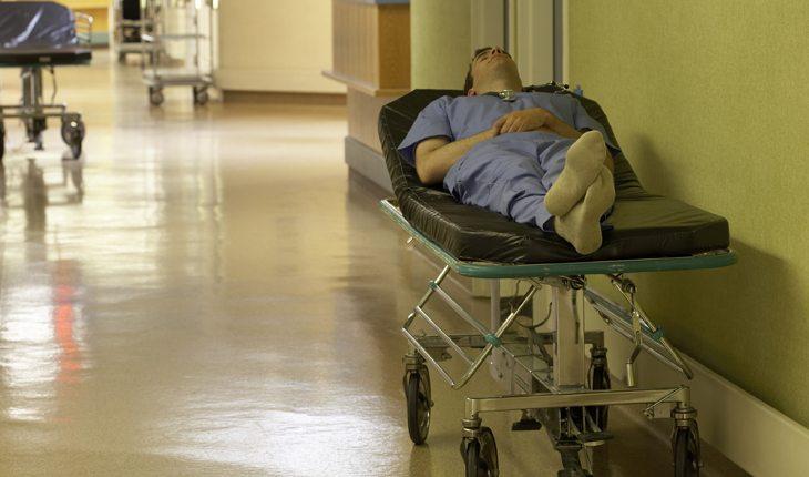 médico deitado em maca no corredor do hospital