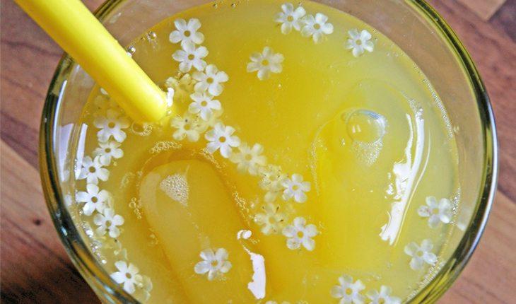 Na foto há um copo com suco de melão e limão com um canudinho amarelo.