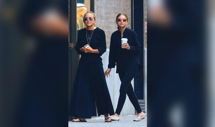 irmãs Olsen vestem looks totalmente pretos enquanto passeiam pelas ruas nova iorquinas. Mary-Kate veste pantalona com suéter e chinelos, enquanto Ashley veste camisa e calça skinny combinadas com mocassim off-white