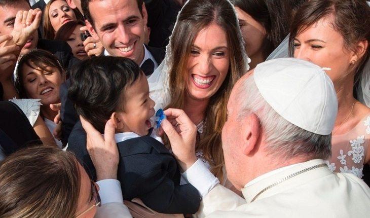 Na imagem, o papa brinca com o bebê da noiva. Casamento abençoado.