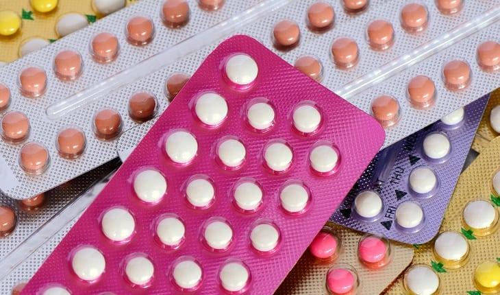 Na imagem, muitas cartelas de pílula contraceptiva estão umas em cima das outras. Dúvidas com um ginecologista.