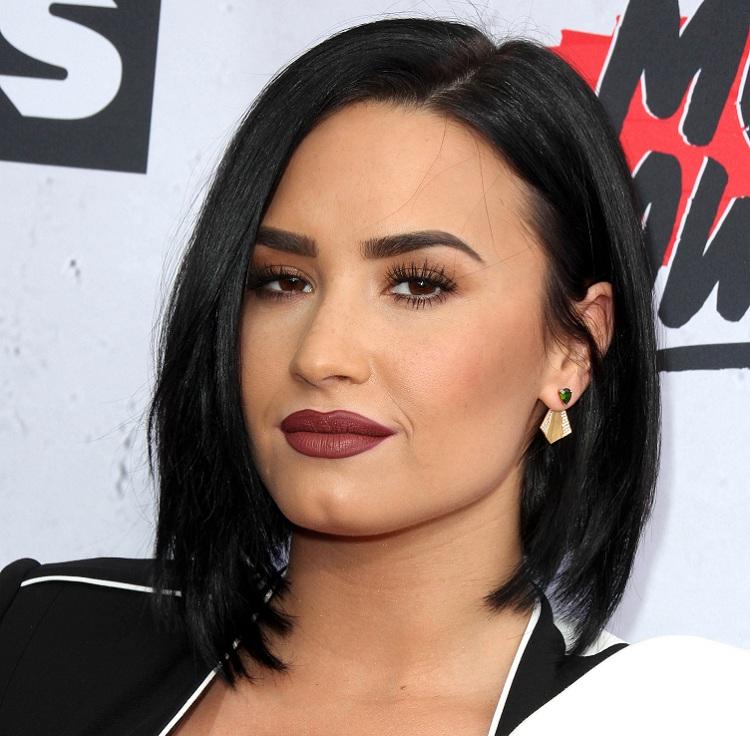 O cabelo chanel desfiado versátil e moderno de Demi Lovato é realçado com a coloração castanho-escuro, que tem a manutenção prática