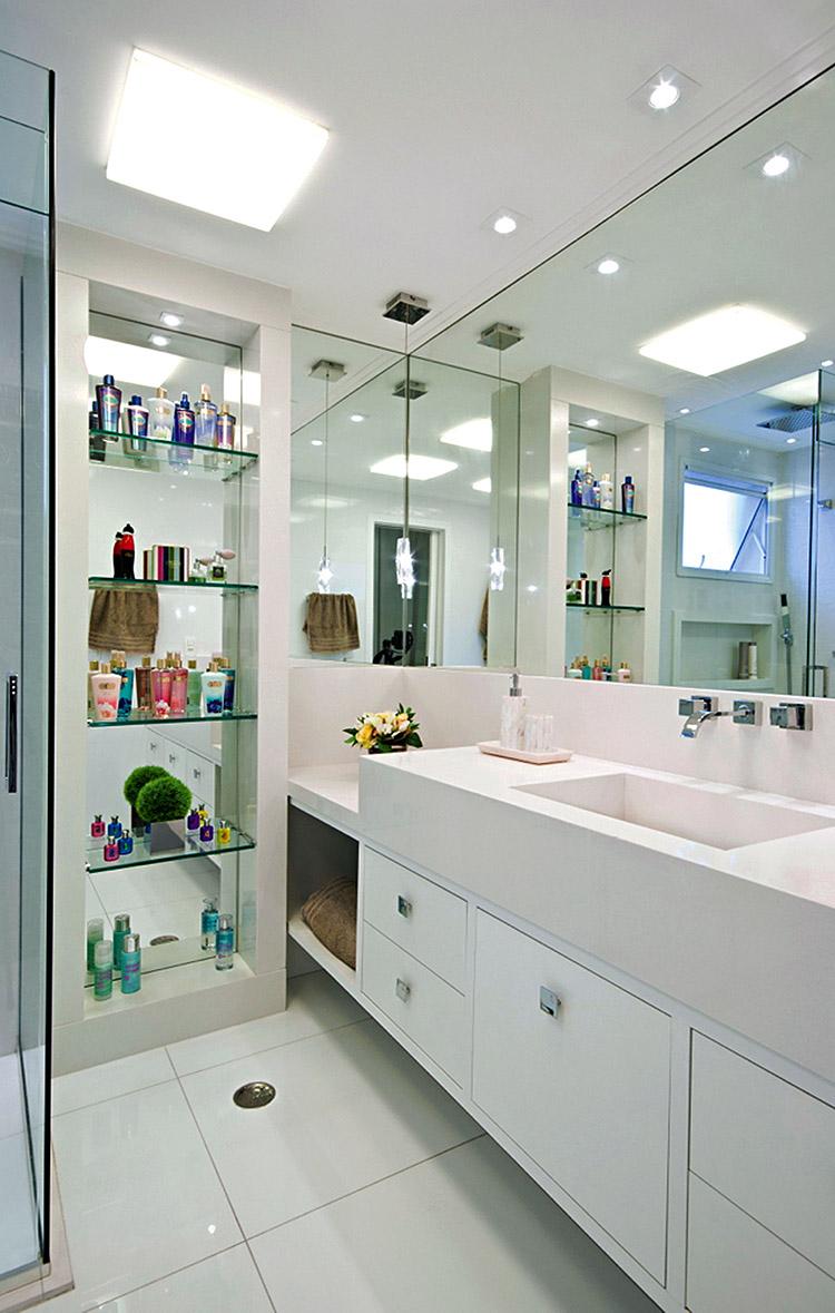 Banheiro com espelhos e revestimentos em branco 