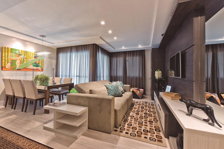 As salas integradas formam um espaço muito aconchegante devido à disposição dos móveis e também à escolha dos tons marrons no ambiente