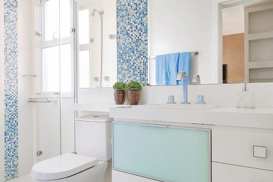 Banheiro com pastilhas azuis e espelho nas paredes 