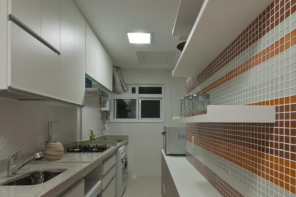 Neste projeto, a arquiteta Cyntia Sabát uniu cozinha e lavanderia, pensando na praticidade do dia a dia e também em aproveitar da melhor maneira o espaço reduzido. Confira outros truques utilizados pela profissional