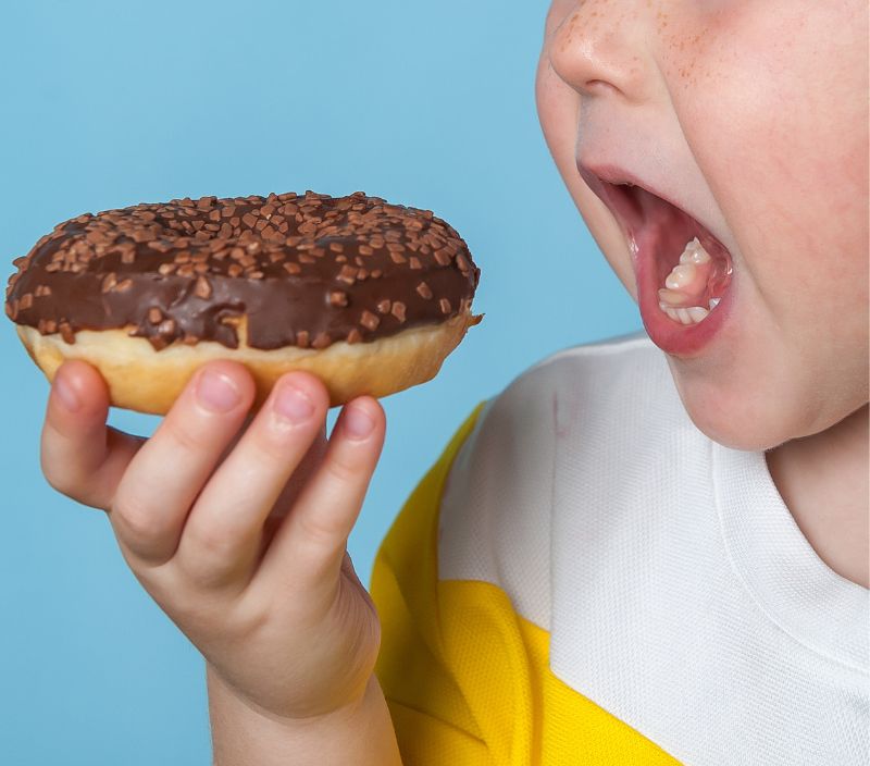 Criança comendo alimento ultraprocessado