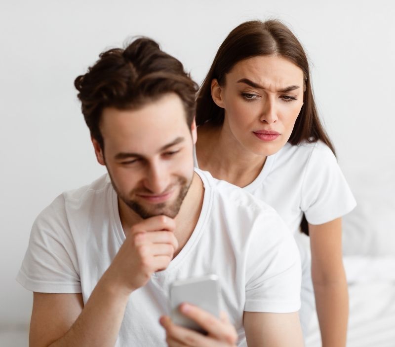 mulher tentando ver o que homem está olhando no celular