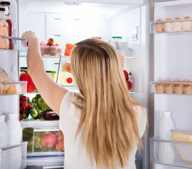 Mulher em frente a geladeira