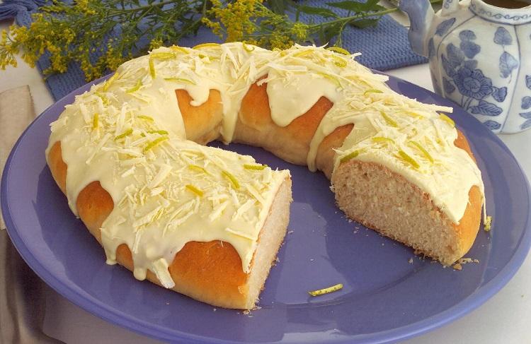 rosca de limão siciliano sobre um prato azul e com raspas de limão por cima