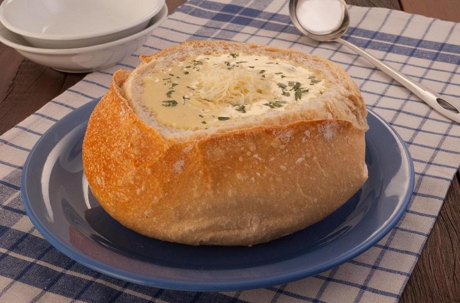 receita de sopa-creme de mandioquinha no pão italiano, polvilhada com cebolinha picada e queijo ralado.