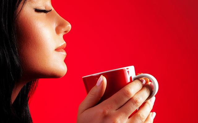 Mulher tomando café em xícara vermelha