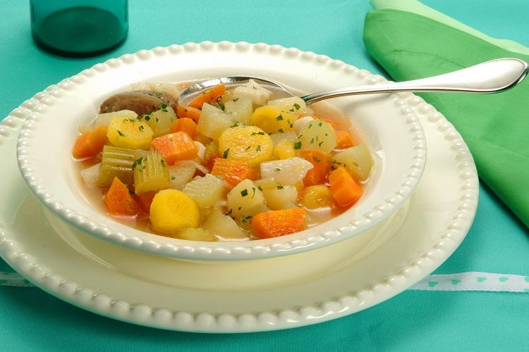 Sopa de legumes no prato com colher