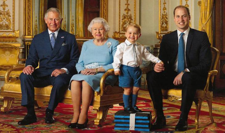 Phillip, Elizabeth, George e William posam para foto em um salão real. George é o único em pé e está sobre 4 livros