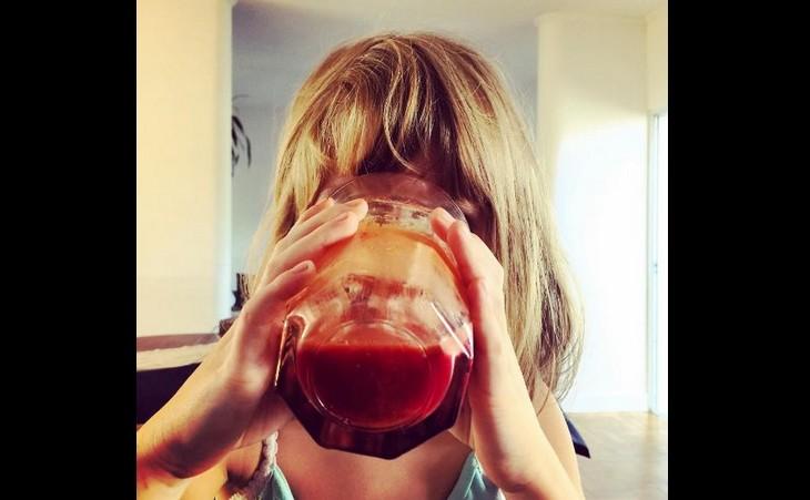 Menina criança de cerca de dez anos toma um suco de beterraba