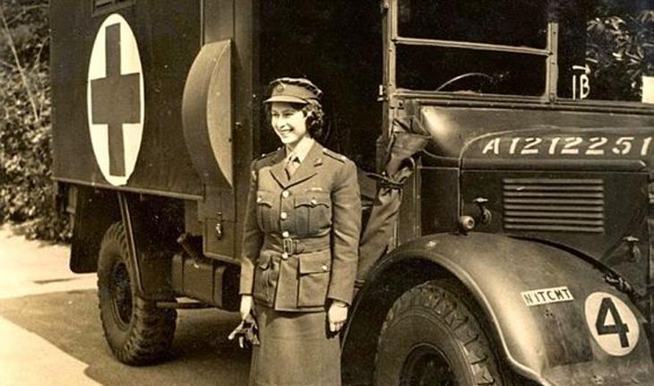 foto em preto e branco antiga de Elizabeth na época do exército. Ela está parada ao lado de um caminhão do exército