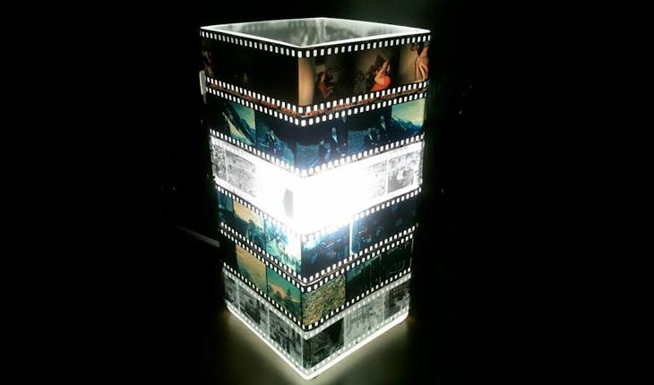 luminária de cuba transparente com negativos colados ao redor