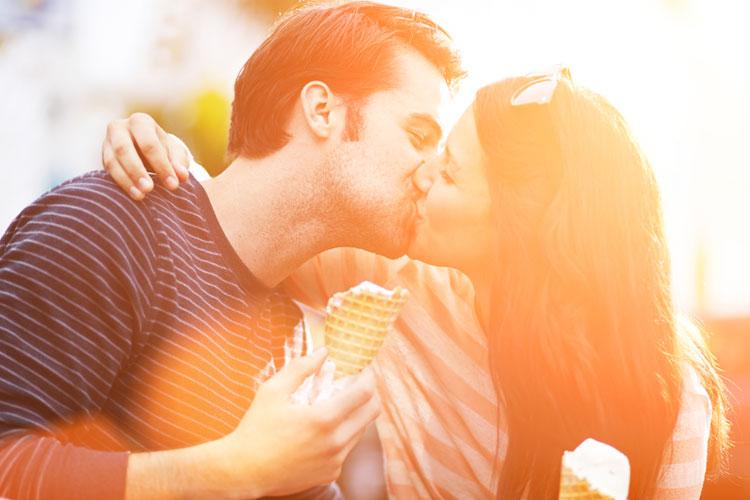casal se beijando enquanto seguram sorvete